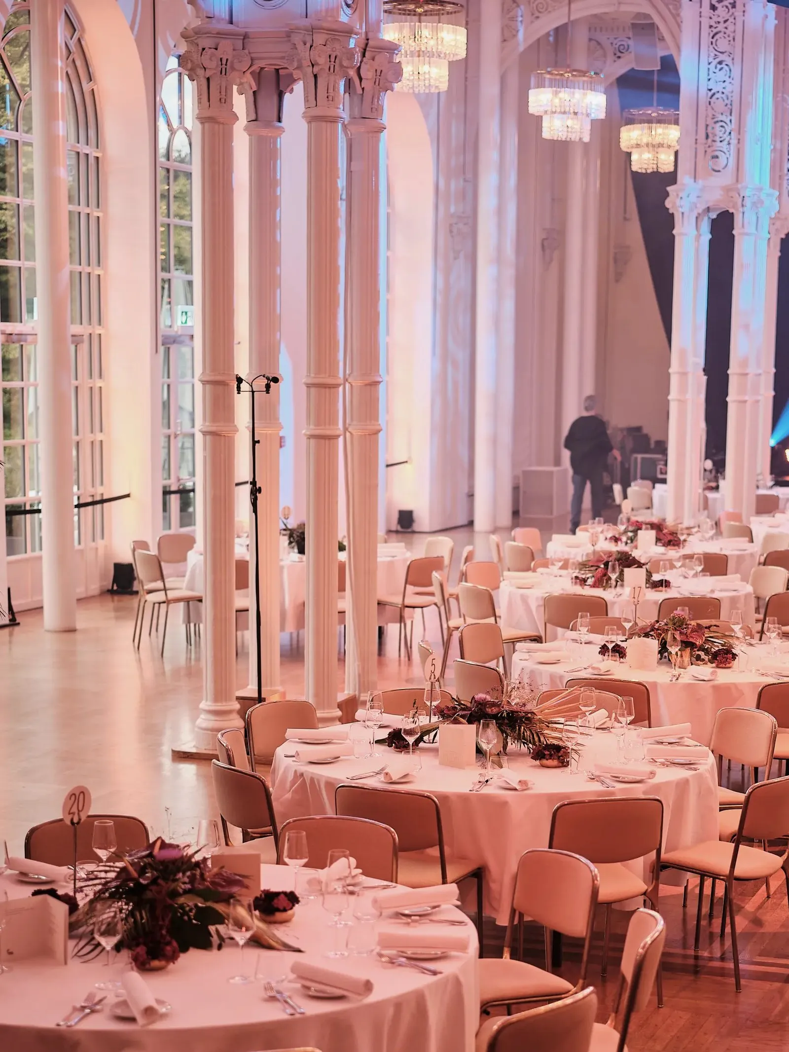 Der Festsaal der Flora mit weißen Säulen, Kronleuchtern und hohen Fenstern zum Park