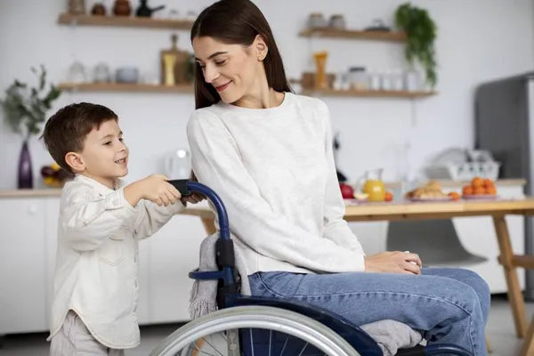 Kind und Mutter im Rollstuhl in der Küche