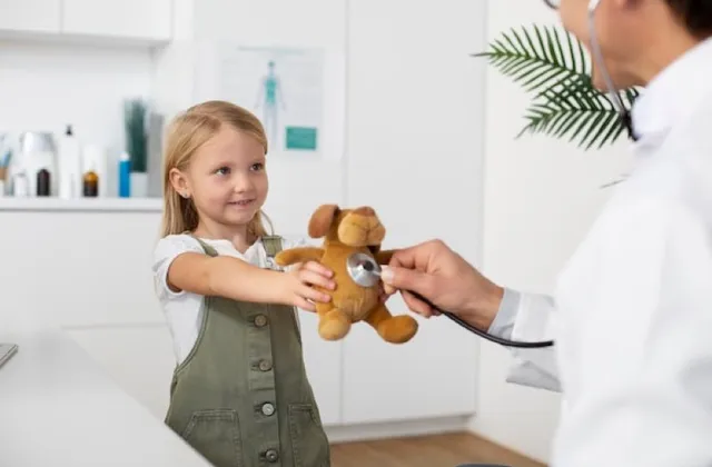 Arzt untersucht den Teddybär eines Mädchens